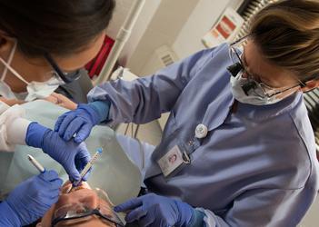 一名布法罗大学的学生正在给病人做牙科手术